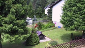 A house with a white exterior, surrounded by dense green trees and a well-maintained lawn. - Lovely, quiet 4-star apartment for two - close to village and lake - Wi-Fi (Titisee-Neustadt)
