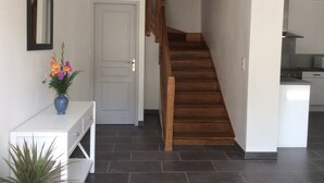Ein modernes Interieur mit Treppe, einer weißen Tür und einer kleinen Küchenzeile.