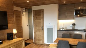 A modern kitchen with wooden cabinets, a built-in microwave, and a dishwasher. - SKIS ON FOOTS-WIFI- GARAGE (optional) -NICE VIEW-2 ROOMS (Les Allues)