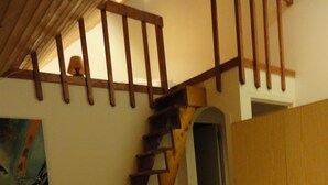A bedroom with a wooden staircase, a bed, and a wardrobe. -    Comfortable apartment in chalet with splendid view   (Allos)