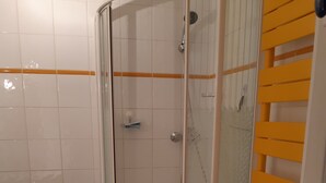 Ein Badezimmer mit Duschkabine, Toilette und Waschbecken.