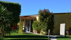 Una casa con un patio, un jardín y un camino que lleva a la entrada.