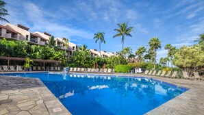 A pool area with a clear blue pool, lounge chairs, and palm trees. - Large 3 Bedroom Condo Across From Beach! Pool & Hot Tub Access! Ocean View! (Kihei)