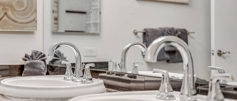 A bathroom with two sinks, a mirror, and a towel rack.