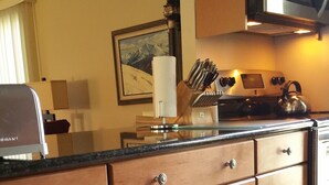Une cuisine avec des meubles en bois, une cuisinière en acier inoxydable et un four à micro-ondes.