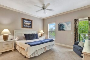 A bedroom with a bed, nightstands, a ceiling fan, and two windows. - ShoreWinds - 4th Floor Poolside in Coligny Plaza! (Hilton Head)