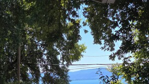 Une vue d’un lac avec un quai et un petit bâtiment, le tout entouré d’arbres.