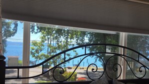 Une pièce avec vue sur un lac, une rambarde en métal et une fenêtre.