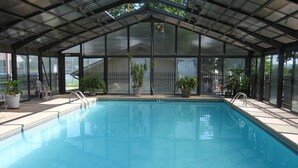 An indoor swimming pool with a covered roof, clear pool water, and a '4 FT' depth marker.