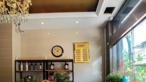 A reception desk with a wooden finish, a wall clock, and a menu board. - Yan Yu Qing Cheng Inn (Chengdu)