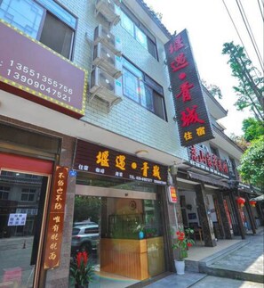 Un immeuble sur lequel on peut voir plusieurs enseignes, dont une pour un hôtel et une autre pour un restaurant.