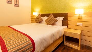 A neatly made bed with a striped blanket, wooden headboard, and two bedside lamps.