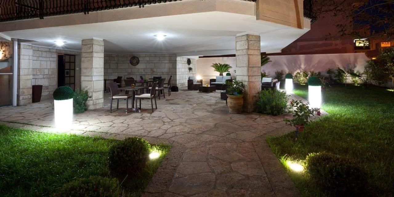 Ein Terrassenbereich im Freien mit Steinböden, Sitzgelegenheiten und Topfpflanzen.