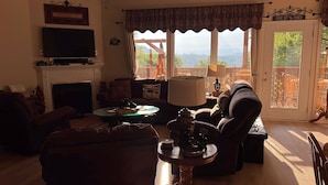 A cozy living room with a fireplace, comfortable seating, and a view of the outdoors. - A piece of Heaven on Earth with all the comforts of home! (Gatlinburg)