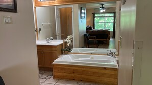 A bathroom with a double sink, wooden vanity, and a large bathtub. - A piece of Heaven on Earth with all the comforts of home! (Gatlinburg)