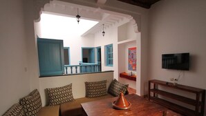 Una sala de estar acogedora con un sofá, una mesa de centro de madera y un televisor.