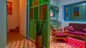 Una sala de estar con un sofá, una silla y una planta en maceta.