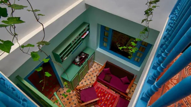 Una habitación con sofá, sillón, una mesita y ventana con vistas.