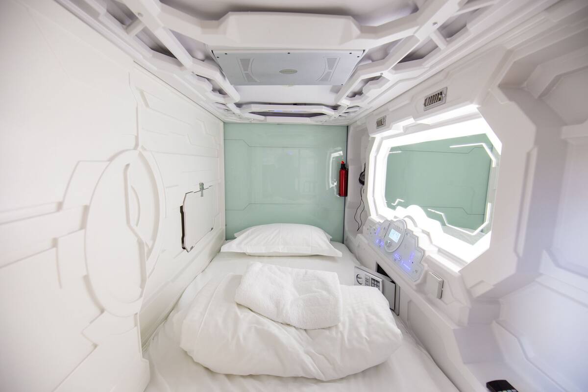 Een kamer met een bed, een raam en een bedieningspaneel.