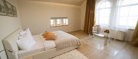 A modern bedroom with a bed, bedside table, and a window with curtains.