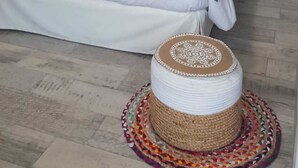 Ein Schlafzimmer mit einem Bett, einem weißen Kleiderschrank und einer Wand mit gerahmten Bildern.