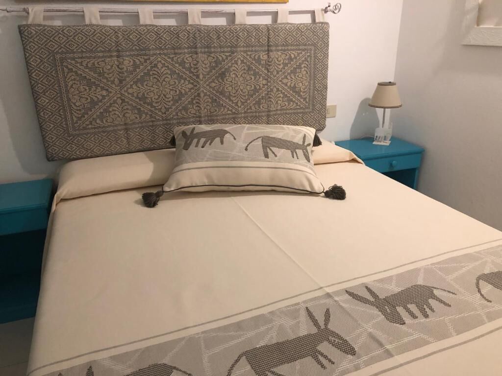 A bed with a patterned headboard and a pillow with animal designs.