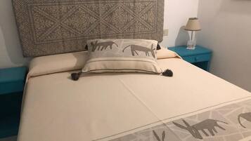 A bed with a patterned headboard and a pillow with animal designs.
