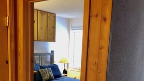 Une chambre à coucher avec un lit, une table de chevet, une lampe et une fenêtre avec des stores.