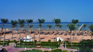A beach resort with rows of palm trees, beach chairs, and umbrellas. - Edge Rotana Sea Beach (Sharm El Sheikh)
