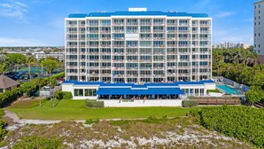 Un hôtel à plusieurs étages, doté d’un toit bleu, d’un espace piscine et offrant une vue sur le paysage environnant.