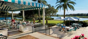 Guests can dine al fresco with a view of the serene lake and palm trees.