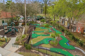 Children can play on the green play structures and miniature golf course in this safe and inviting outdoor space.