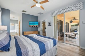 A bedroom with a bed, a ceiling fan, a TV, and a sliding glass door leading to a balcony. - ✦ 7BR Dory Villa ✦ South Pool & Spa ✦ Serene Water & Conservation Views ✦ (Kissimmee)