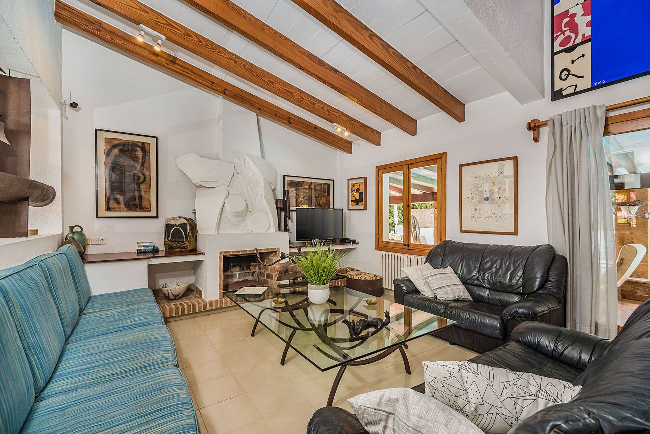 A living room with a sofa, a coffee table, a fireplace, and a television.