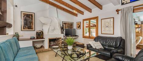 A living room with a sofa, a coffee table, a fireplace, and a television.