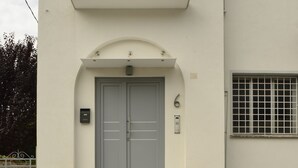A two-story building with a balcony, a double door entrance, and a small window with shutters. - Flat design in Treviso. Easy connection to Venice (Treviso)