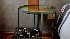A room with a green metal table, a checkered tablecloth, a lamp with an orange shade, and a patterned wallpaper. - Flat design in Treviso. Easy connection to Venice (Treviso)