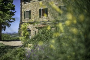 A stone building with arched windows and a view of the countryside.