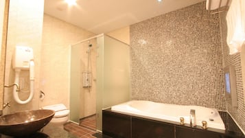 A modern bathroom with a glass-enclosed shower, a large freestanding bathtub, and a vessel sink.
