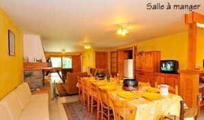 Enjoy meals together at the dining table, which seats four, accompanied by a sofa and TV.