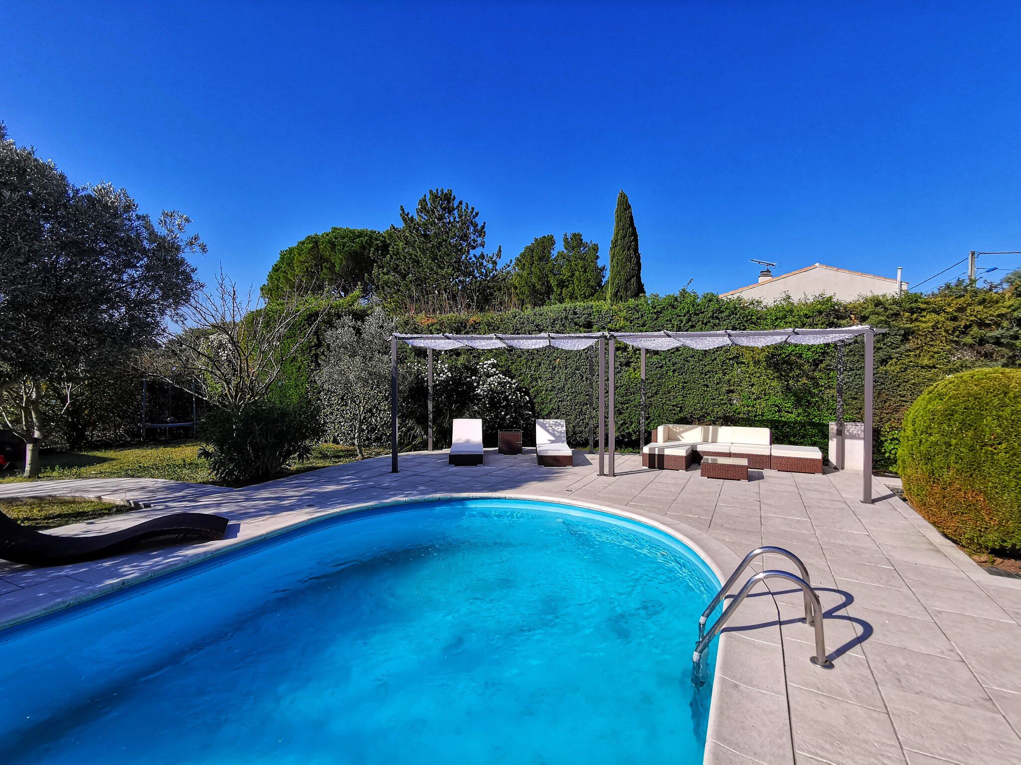 Ein Pool mit Pergola und Liegestühlen.