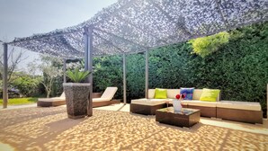 An outdoor seating area with a canopy, cushioned sofas, and a coffee table. - Charming house surrounded by vineyards  (Rochefort-du-Gard)