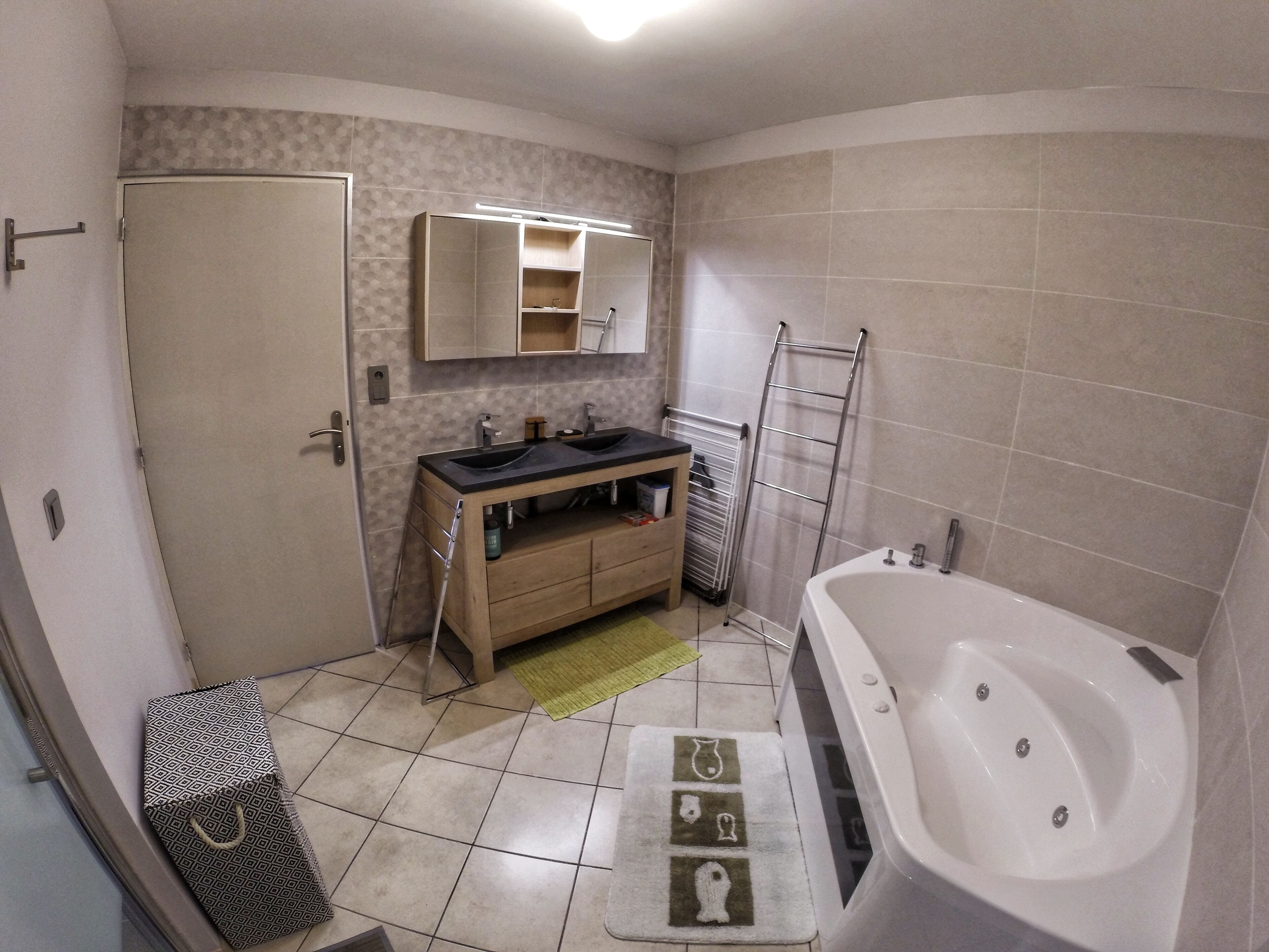 A bathroom with a bathtub, a sink, a vanity, and a towel rack.