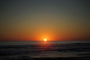 A sunset over a calm sea with no land in view. - La Siesta Troncones  Surf Villa 1 (Troncones)