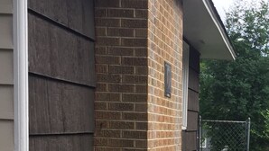 A house with a brick chimney, a wooden siding exterior, and a garden with hydrangea plants. - Manito South Spokane Guest House (Spokane)