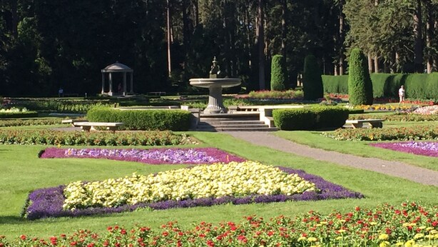 A formal garden with a central fountain, manicured lawns, and a gazebo in the background. - Manito South Spokane Guest House (Spokane)