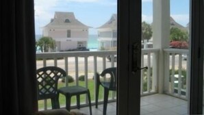 Een balkon met uitzicht op een strand en huizen.
