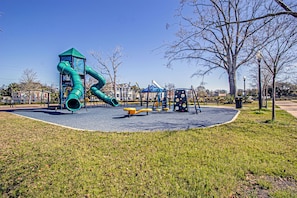 A playground with a green slide and various play equipment.