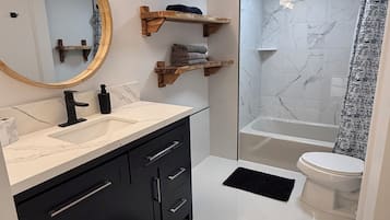 Tina con regadera, secadora de cabello, toallas, shampoo