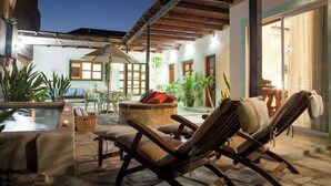 An outdoor patio with lounge chairs, a small pool, and potted plants.